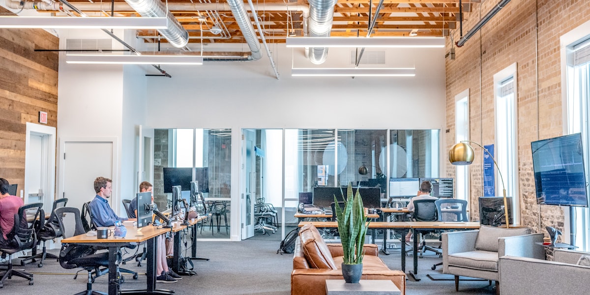Open-plan office with a sparsely occupied floor, representing a widening split between AI roles and broad IT hiring